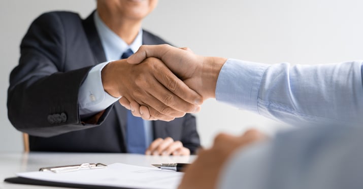 Two men shaking hands and one of them has been hired as a consultant for CMMC